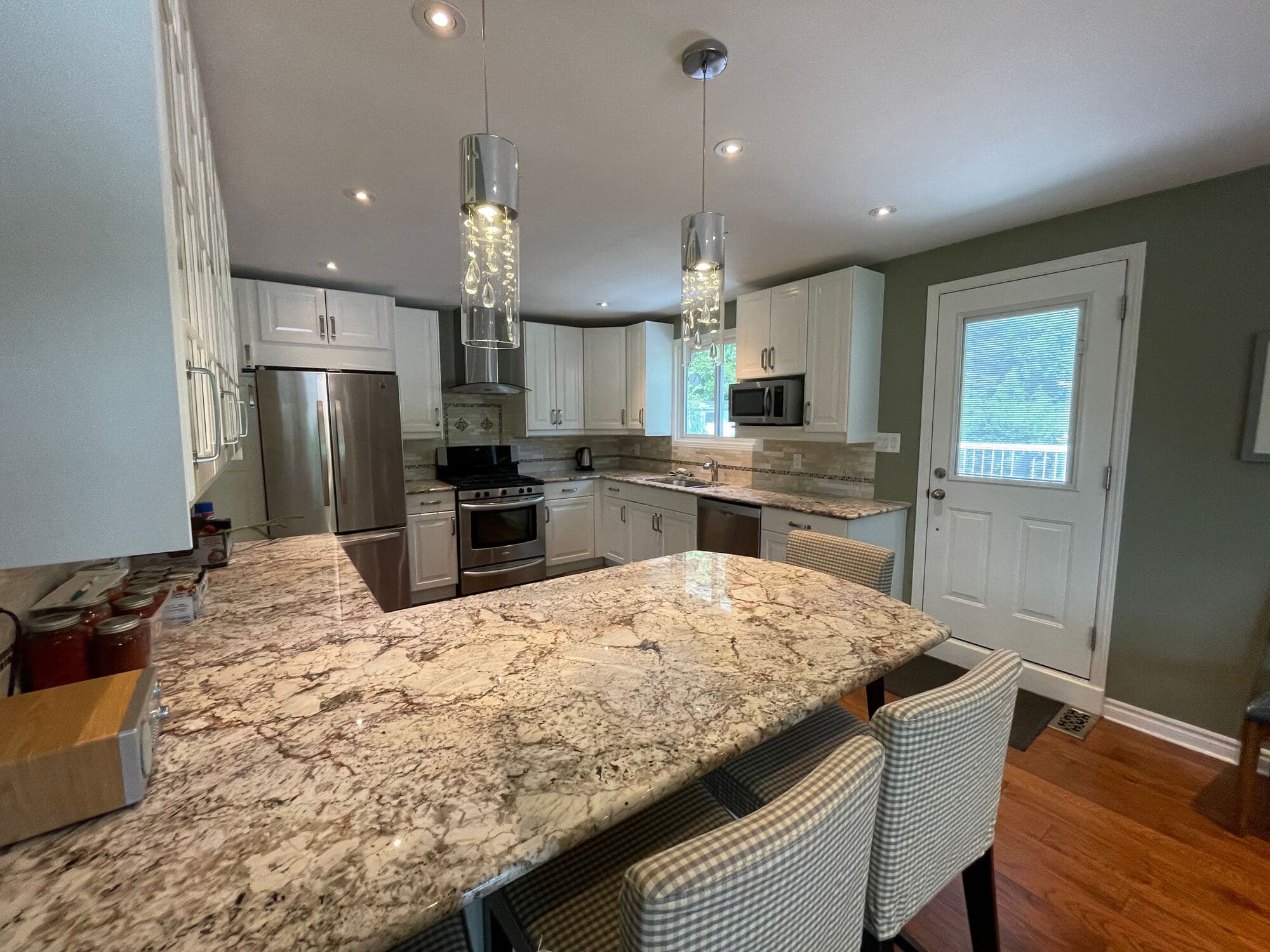 Renovated kitchen with granite island and pendant lighting